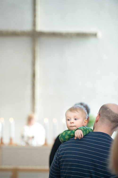 Lapsi ja mies kirkossa, taustalla näkyy alttari.
