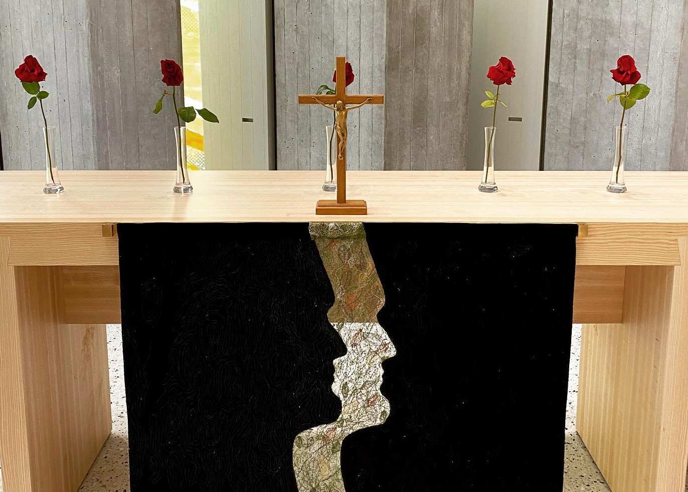 Altarilla on musta antependium ja alttarin päällä punaisia ruusuja.
