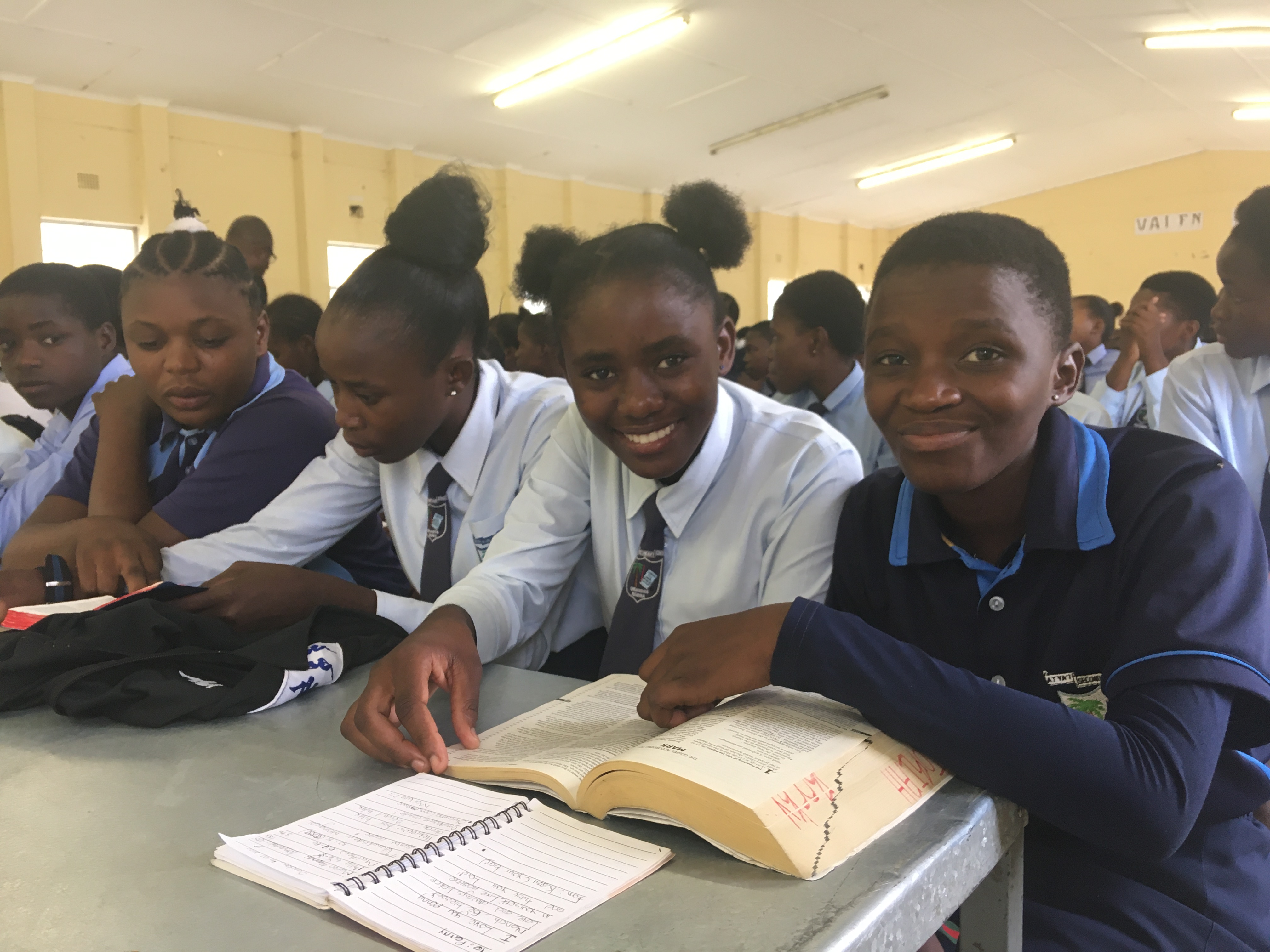 Namibialaisia nuoria opiskelemassa Raamattua pöydän äärellä.