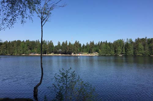 Luonnon vaikutukset mielen hyvinvointiin - Tapaaminen Kuusijärvellä Näkymä Kuusijärven yli rannalta toiselle, keskellä sininen järvi.