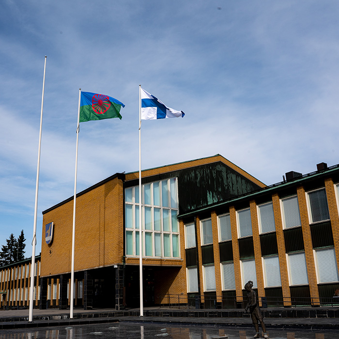 Suomenlippu ja romanilippu salossa Vantaan kaupungintalon edustalla.