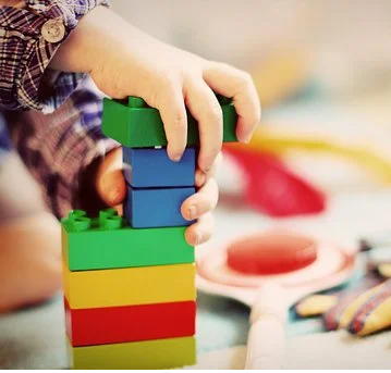 Päiväkerho ulkona Lapsi rakentaa legoja