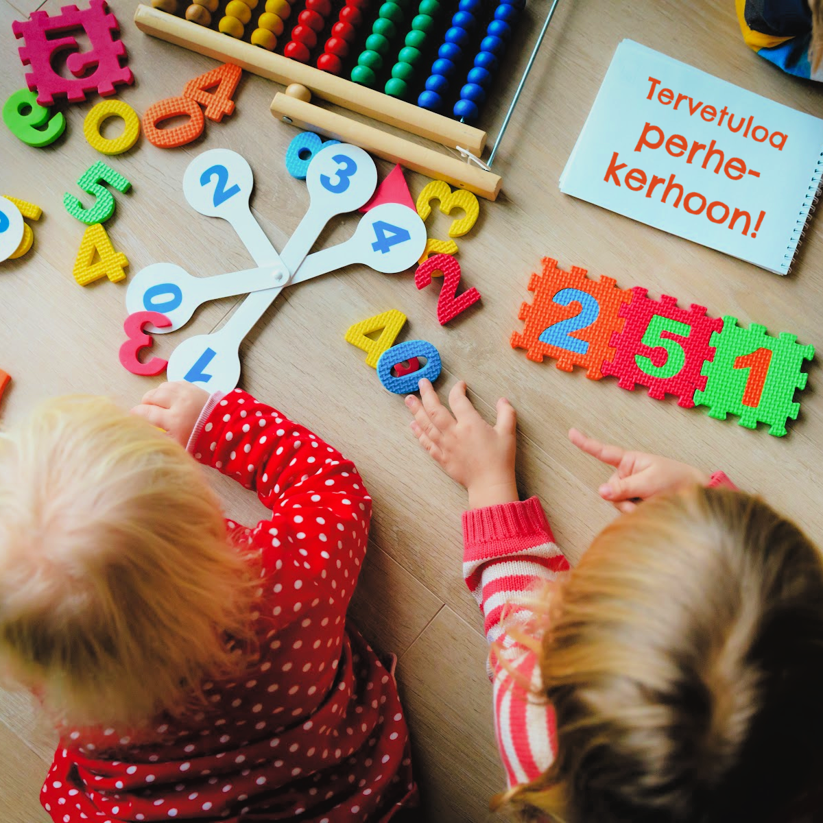 Ilolan perhepäivä lapset leikkii numeroleluilla lattialla maaten