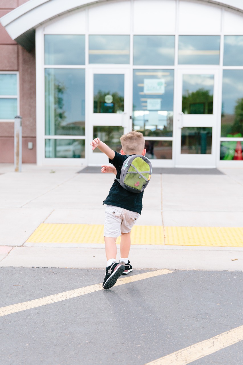 Poika menossa kouluun reppu selässä.