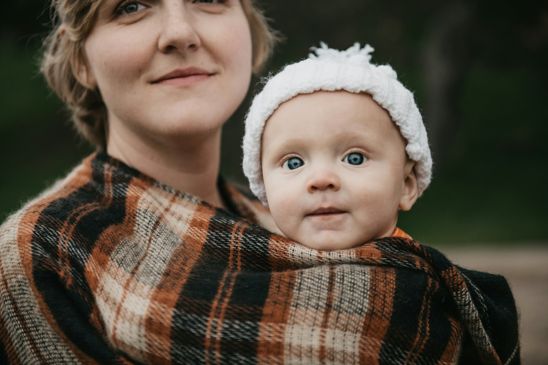 Äitienpäivän messu - Jumalan kansan koti-ikävä Kuvassa äiti ja saman villahuivin sisältä katseleva pienokainen.