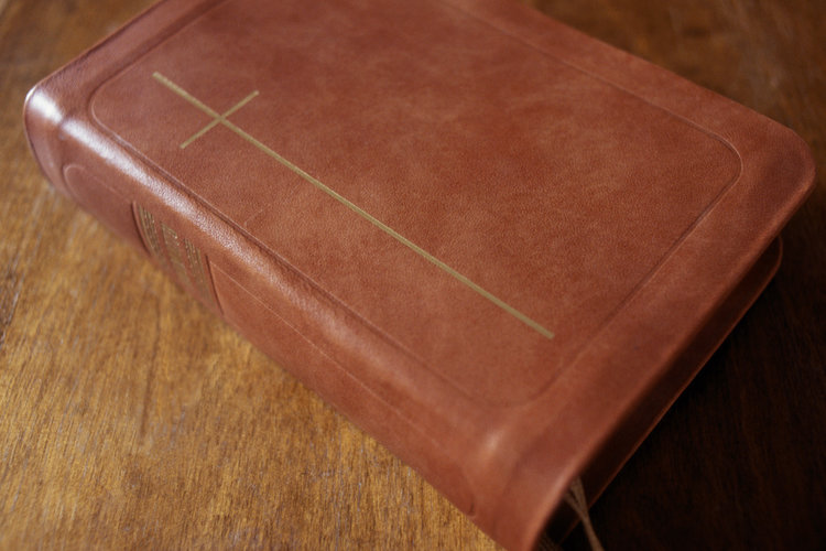 Kuvassa on ruskea Raamattu pöydällä.