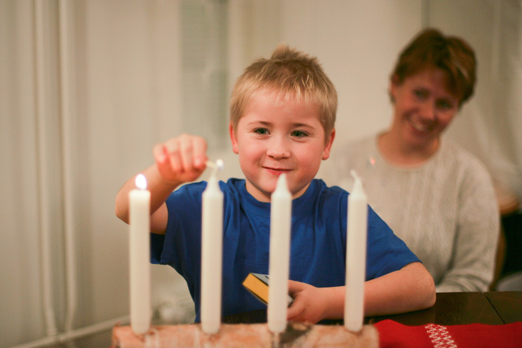 Poika sytyttää adventtikynttilää