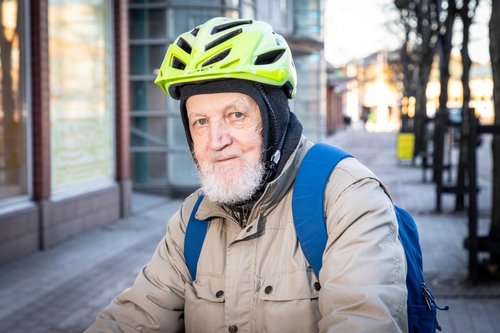 Pekka Kivekäs polkupyörän selässä, pyöräilykypärä päässä.