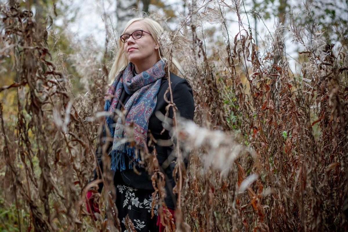 Pappi Laura Sydänmaanlakka ulkona kuihtuneiden horsmanvarsien keskellä 