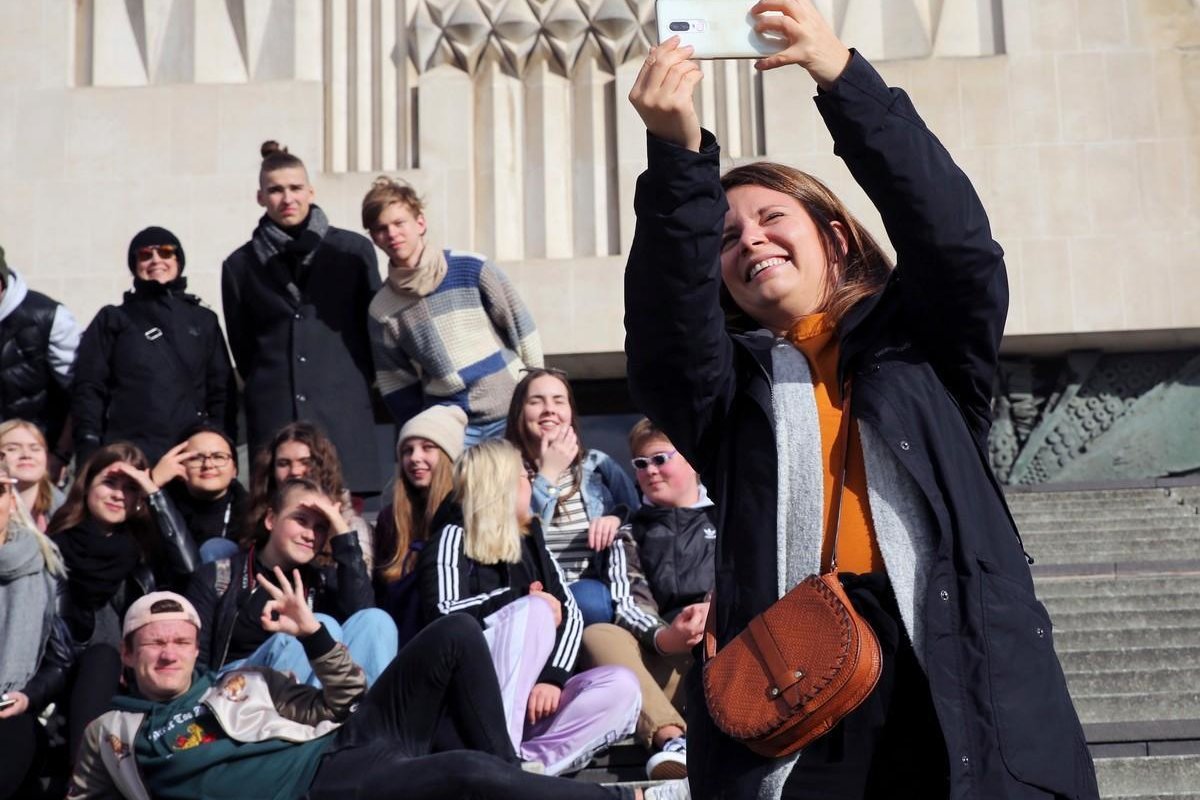 Nuorisotyönohjaaja Riikka Hillebrand ottaa selfien isosryhmän kanssa.