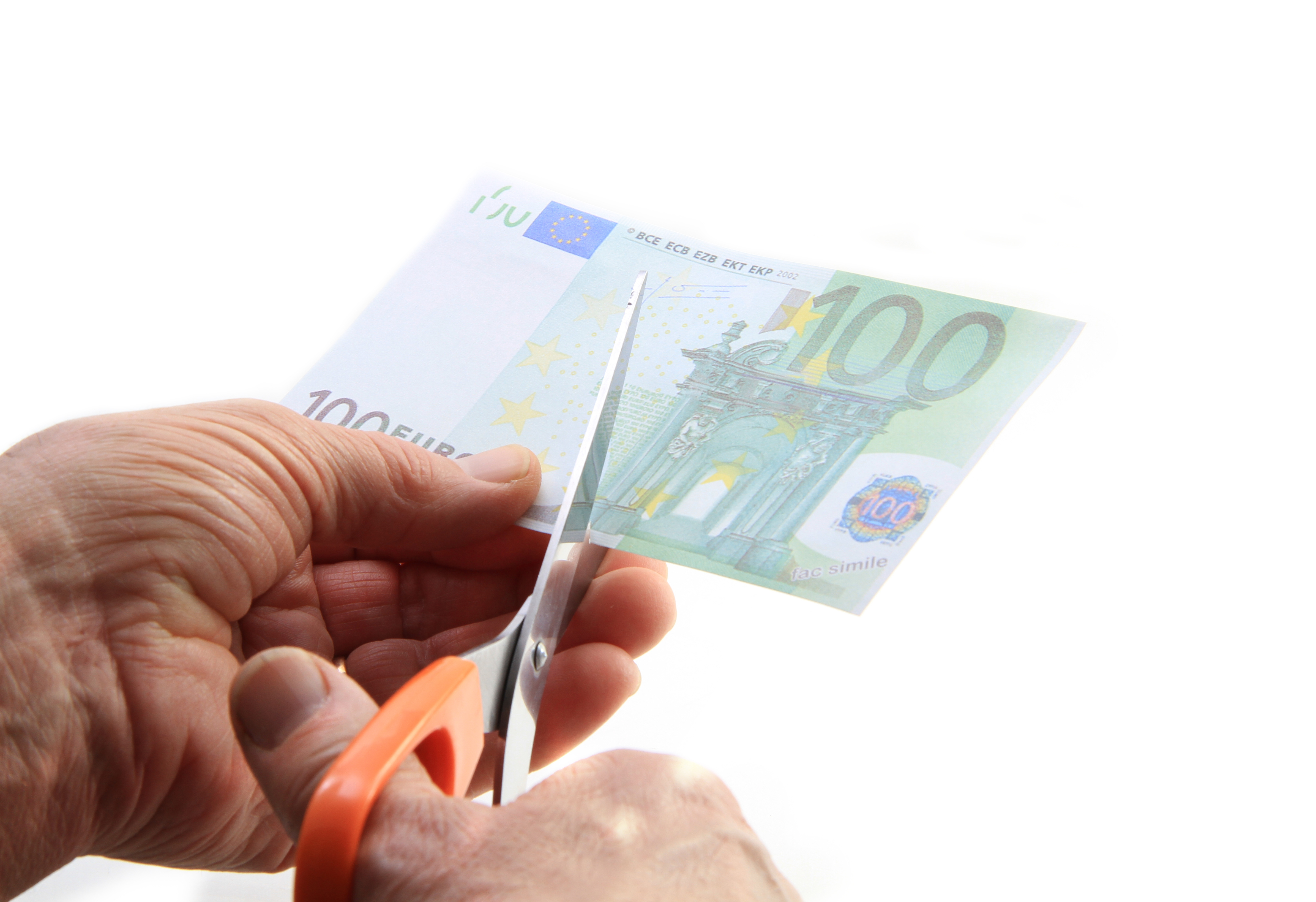 100 euron seteliä leikataan saksilla kahtia