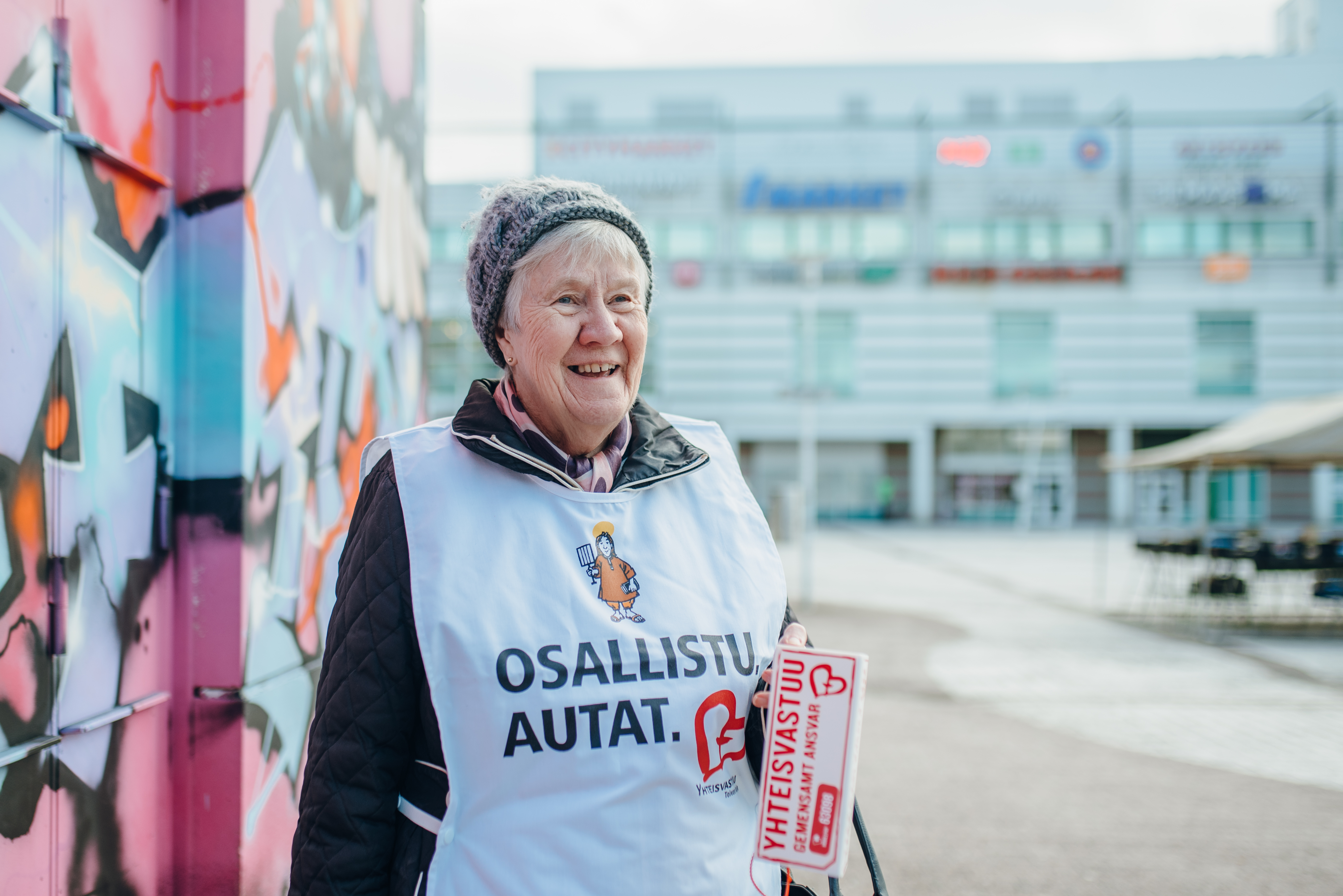 Yhteisvastuukeräyksen vapaaehtoinen Mirja Taipale seisoo keräyslipas kädessään Myyrmäen Paalutorilla.