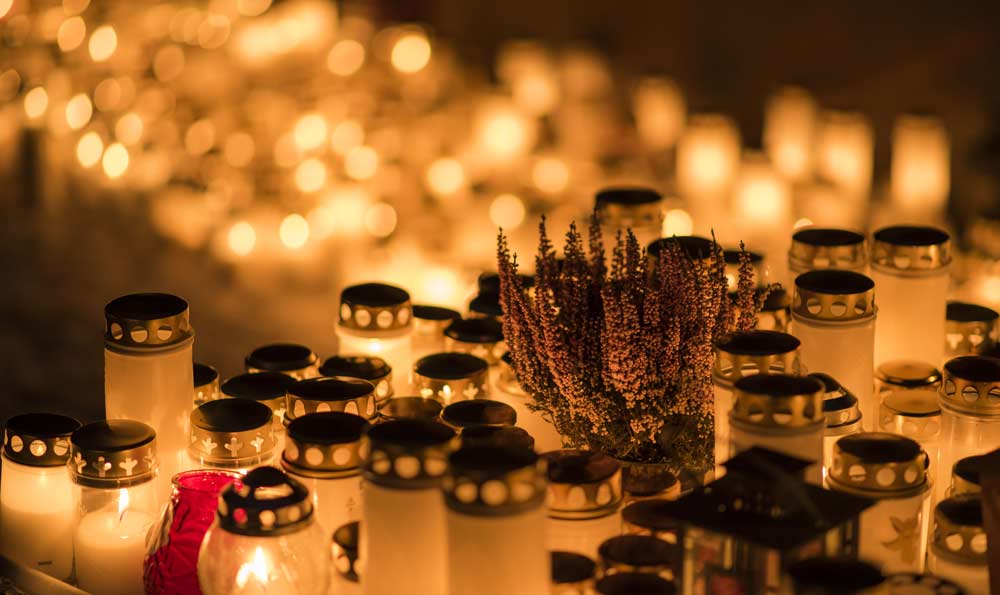 Paljon kynttilöitä hautausmaalla.